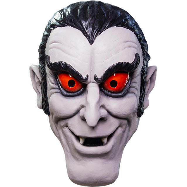 Mask, front view.  Pale lavender gray cartoon vampire face. black hair with widow's peak, upturned black eyebrows, red-orange eyes, pointed ears, mouth open showing fangs.