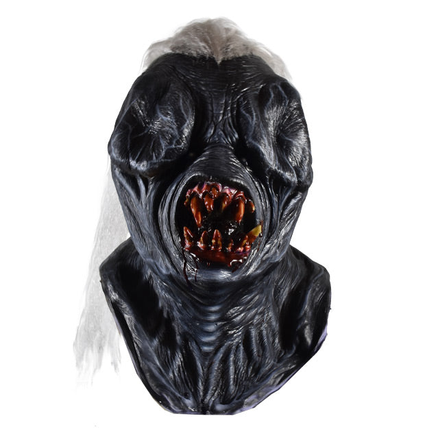 Mask, front view, head, neck and upper chest.  Long white hair in center of head.  Black skin, wrinkled, nearly nonexistent eyes and nose.  Large round gory mouth with sharp bloody teeth.  