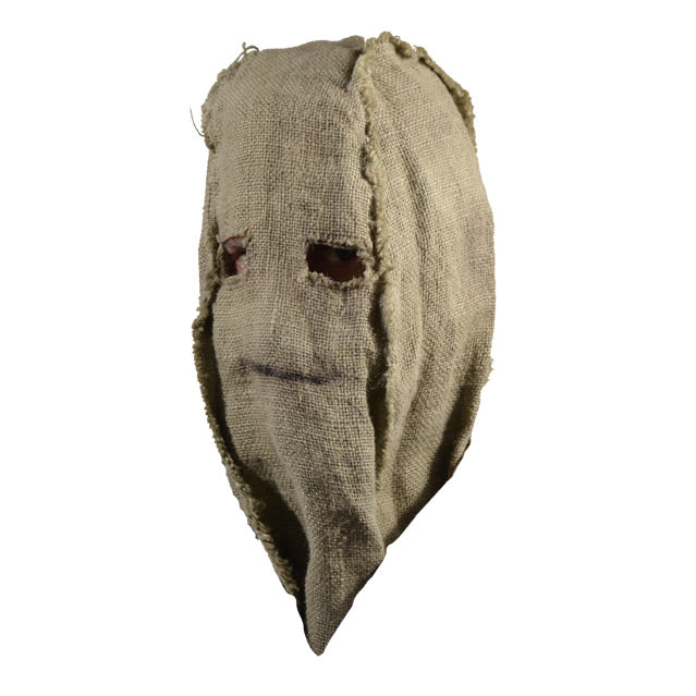 Mask, left view. Simple burlap sack with holes for eyes, black line drawn for mouth.