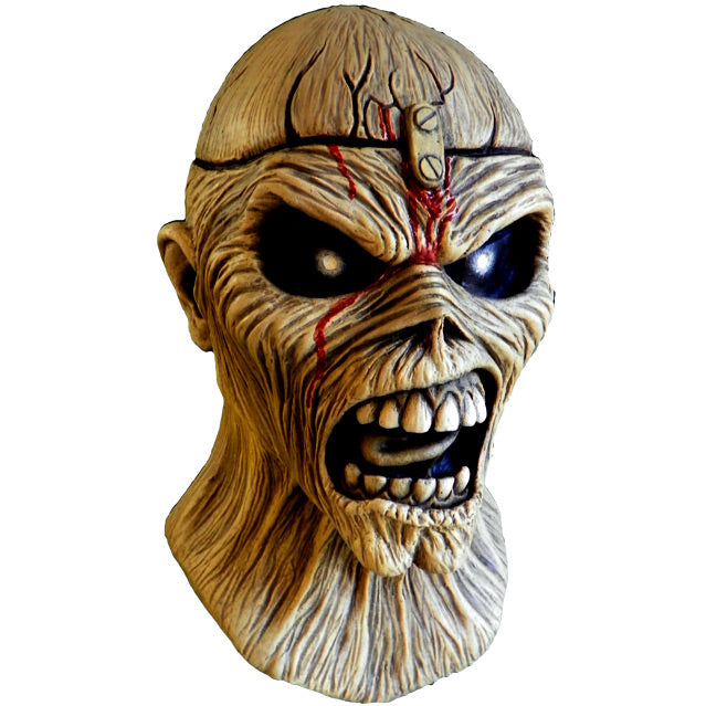 Mask, head and neck, right view. Iron Maiden Eddie, tan, blood coming from middle of forehead large black eyes, open scowling mouth showing teeth.