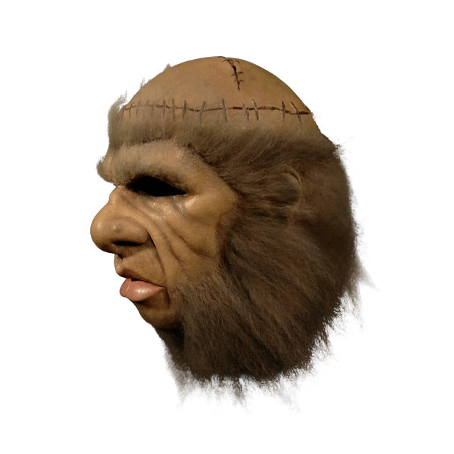 Monster mask right side view, stitched scalp, thick brown hair around entire face, large nose and lips.