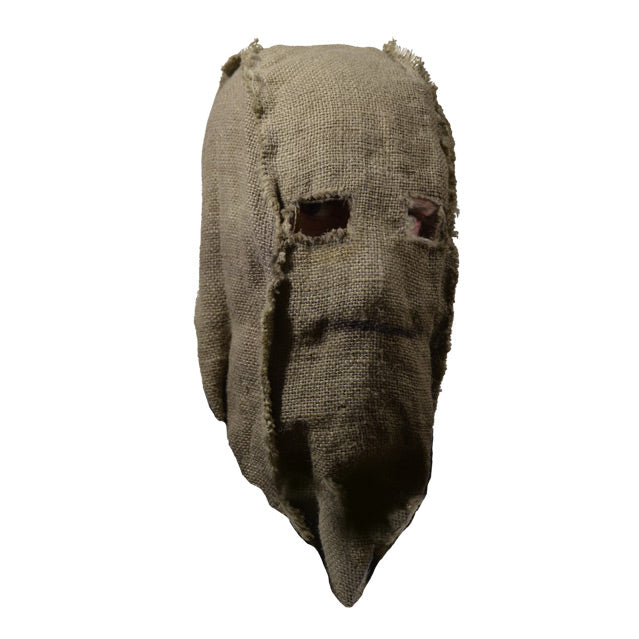 Mask, right view. Simple burlap sack with holes for eyes, black line drawn for mouth.
