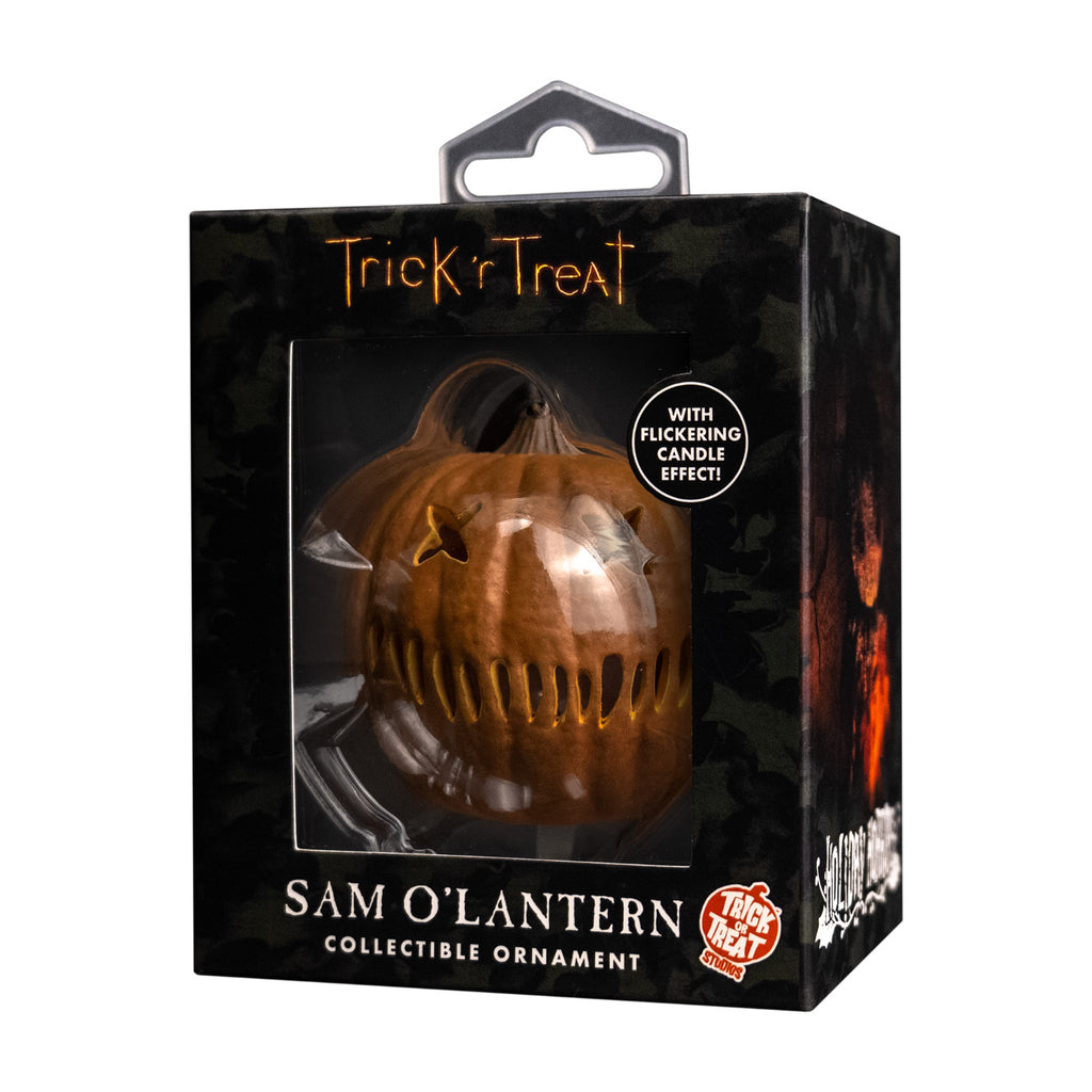 Product packaging.  Black window box showing ornament.  Text reads Trick r' Treat, with flickering candle effect, Sam o' lantern, collectible ornament. orange and white Trick or Treat Studios logo.