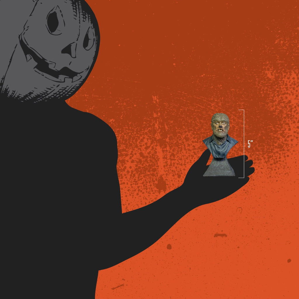 Orange background. Person wearing black, jack o' lantern head, holding mini bust to show size, 5 inches
