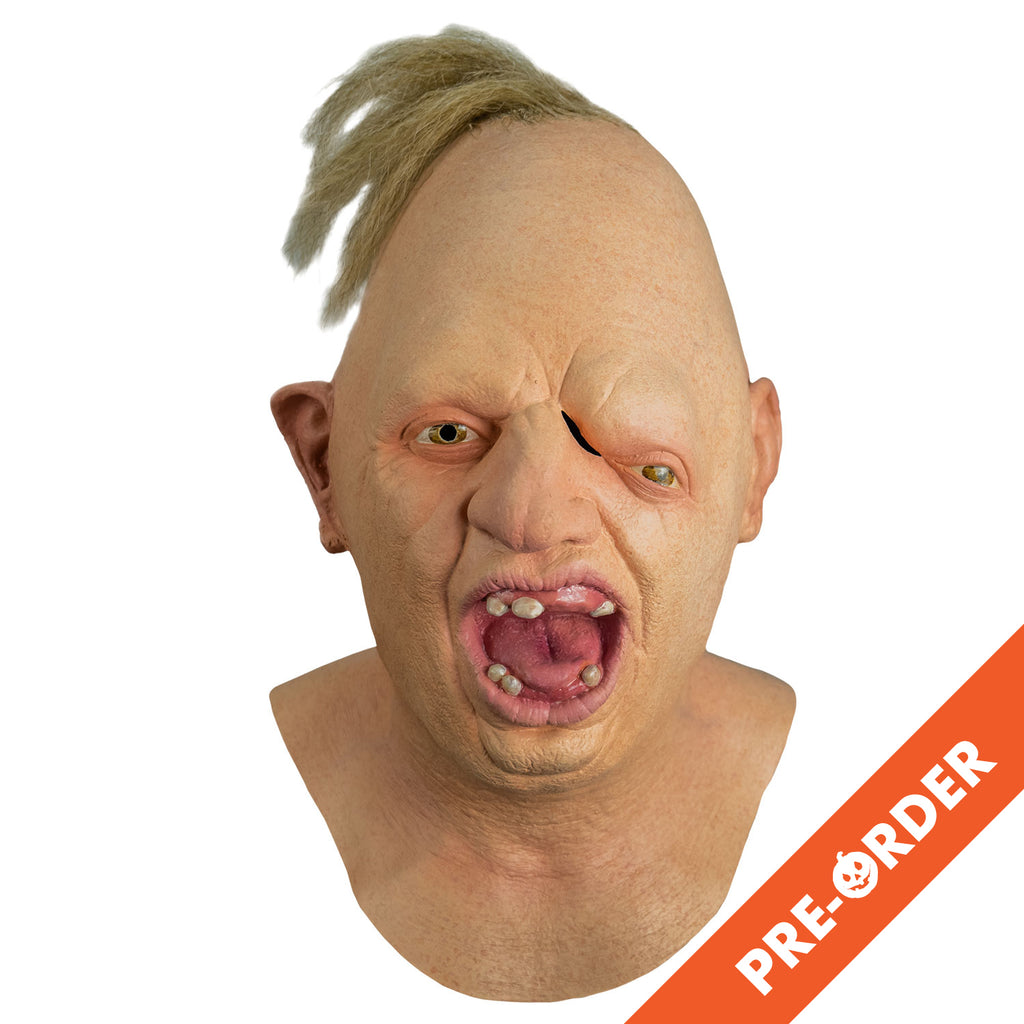 white background, orange diagonal banner bottom right, white text reads pre-order. Mask, front view, head, neck and upper chest. Egg shaped head, tuft of disheveled blond hair on top. No eyebrows, light brown eyes offset, left eye lower than the right. Large crooked nose. Deformed right ear. Mouth wide open showing pink tongue and gums and only six teeth.