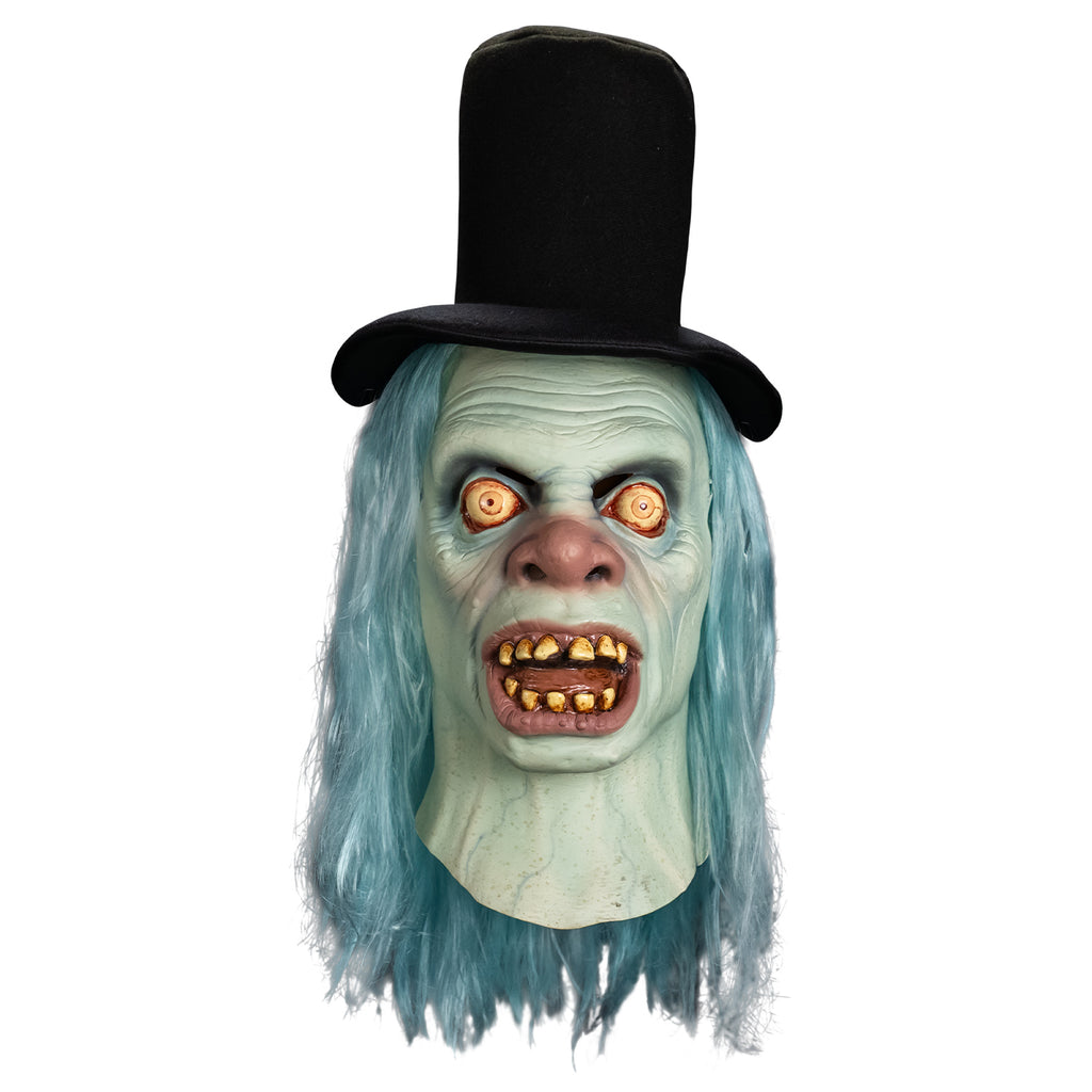 Mask front view, head and neck.  Black top hat. Long, straight, light blue hair. Pale blue wrinkled skin.  No eyebrows, large, wide open, bloodshot yellow eyes.  Large, bulbous pink nose.  Mouth, wide open showing tongue and dirty yellowed teeth, large pink lips.  blue veins showing on neck.   
