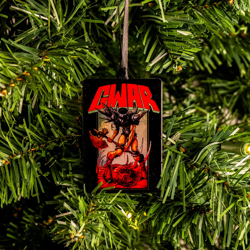 GWAR Metal ornament hung on Christmas tree.  Tall black rectangle, large red and yellow text at top reads GWAR. Illustration of an Orange and black muscular creature, wearing black horned helmet, large spiked shoulder armor, red boots, holding a large war axe.  standing over red gore and white bones.