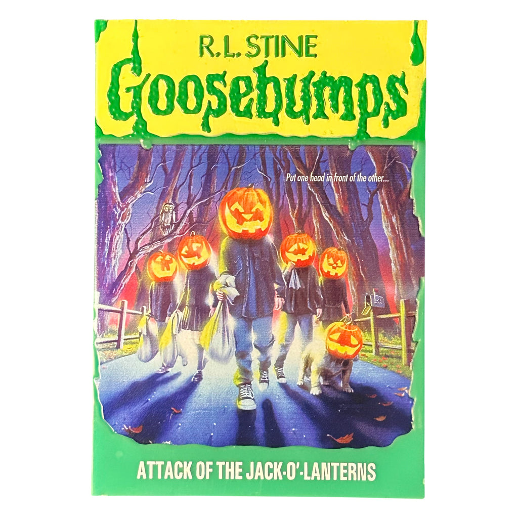 Magnet. Has the appearance of a book cover. Illustration of trick or treaters with jack o' lantern heads, walking on road, fences on both sides, trees in the background. Yellow banner at top, green text reads R.L. Stine, Goosebumps. White text on illustration reads Put one head in front of the other. Green border at bottom, white text reads Attack of the Jack 'o lanterns.