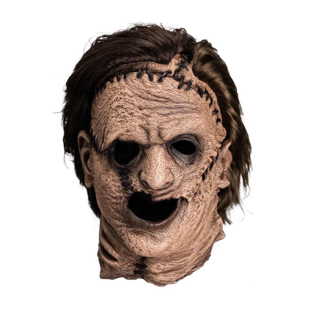 Mask, front view. Leatherface latex mask. Wrinkled sagging skin stitched together brown hair.