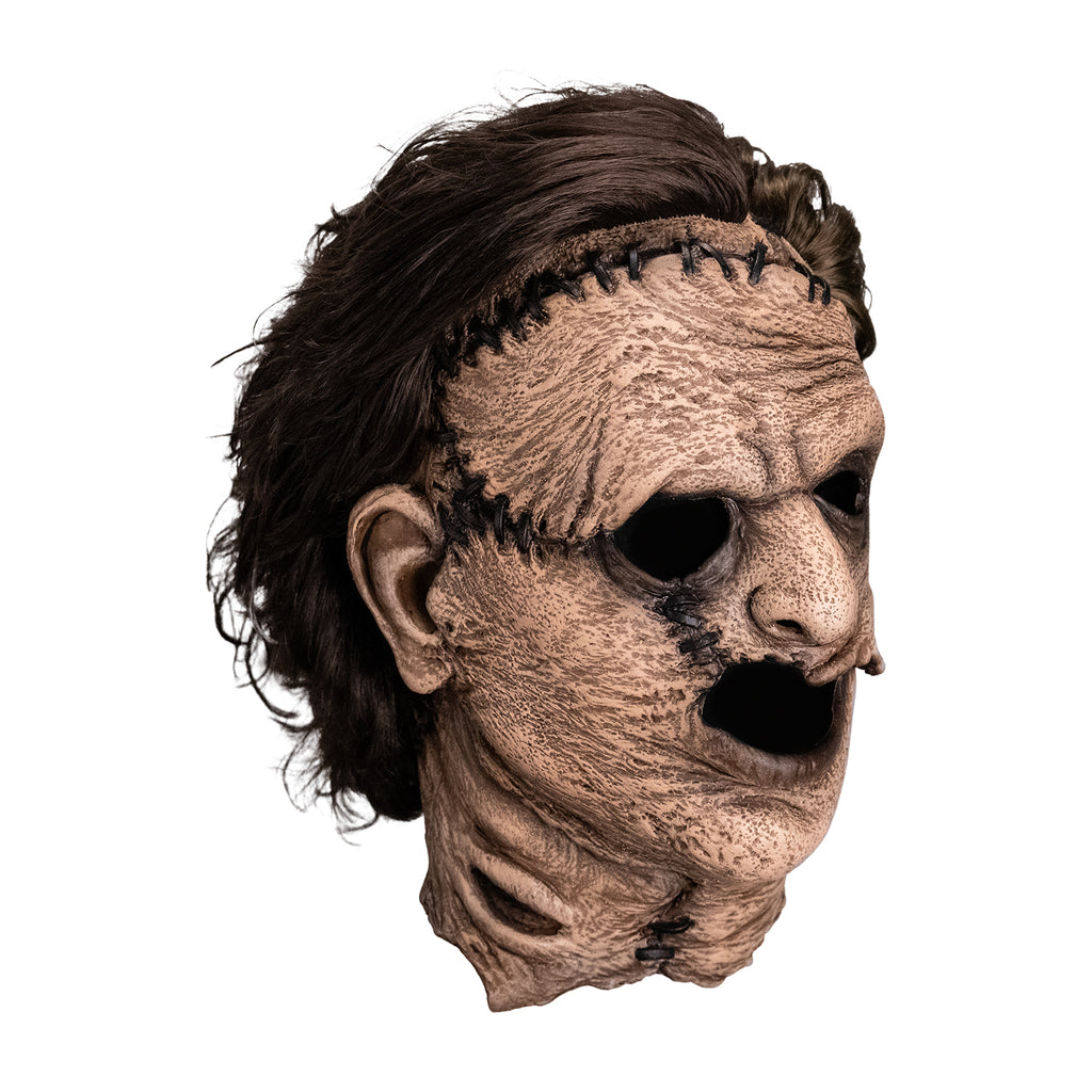 Mask, right side view. Leatherface latex mask. Wrinkled sagging skin stitched together, brown hair.