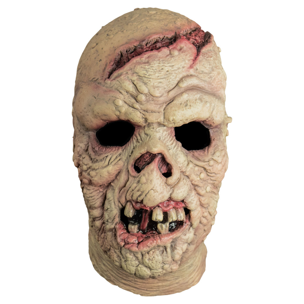 Mask, front view, head and neck.  Bald.  Pinkish, wrinkled and lumpy flesh, large open wound on forehead and crown of head.  missing nose.  Mouth open showing gums, gapped dirty teeth, deformed pink bottom lip.