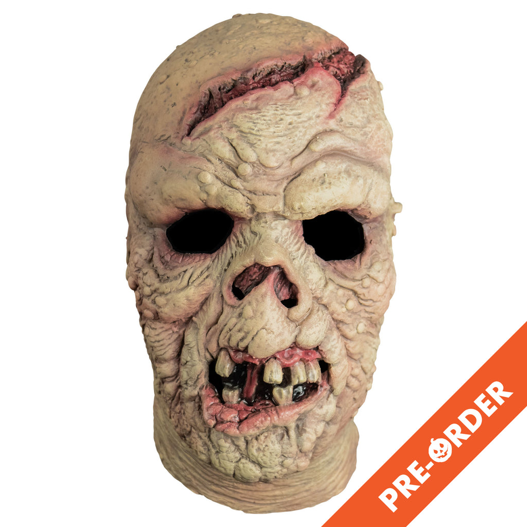 white background, orange diagonal banner bottom right, white text reads pre-order. Mask, front view, head and neck. Bald. Pinkish, wrinkled and lumpy flesh, large open wound on forehead and crown of head. missing nose. Mouth open showing gums, gapped dirty teeth, deformed pink bottom lip.