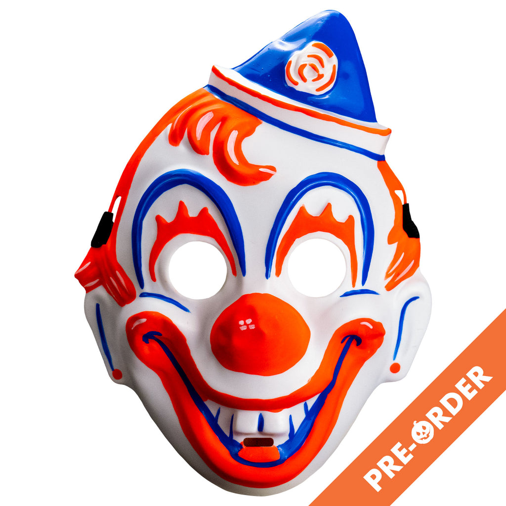 White background, orange diagonal banner bottom right, white text reads pre-order. Face mask, front view. white clown face, blue white and orang triangular hat tipped to the left . orange painted hair. Blue arches around eyes, orange painted eyelashes, blue lines on cheeks and ears, orange dots on earlobes, large orange clown nose. Orange and blue clown mouth in a large smile showing teeth. Black elastic strap at temples