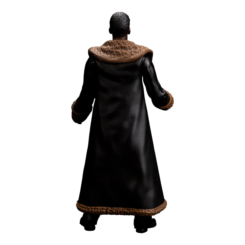 Candyman figure back view. Man short brown hair, brown skin. wearing a full-length black leather coat with tan fur-trimmed large collar and cuffs. black boots.