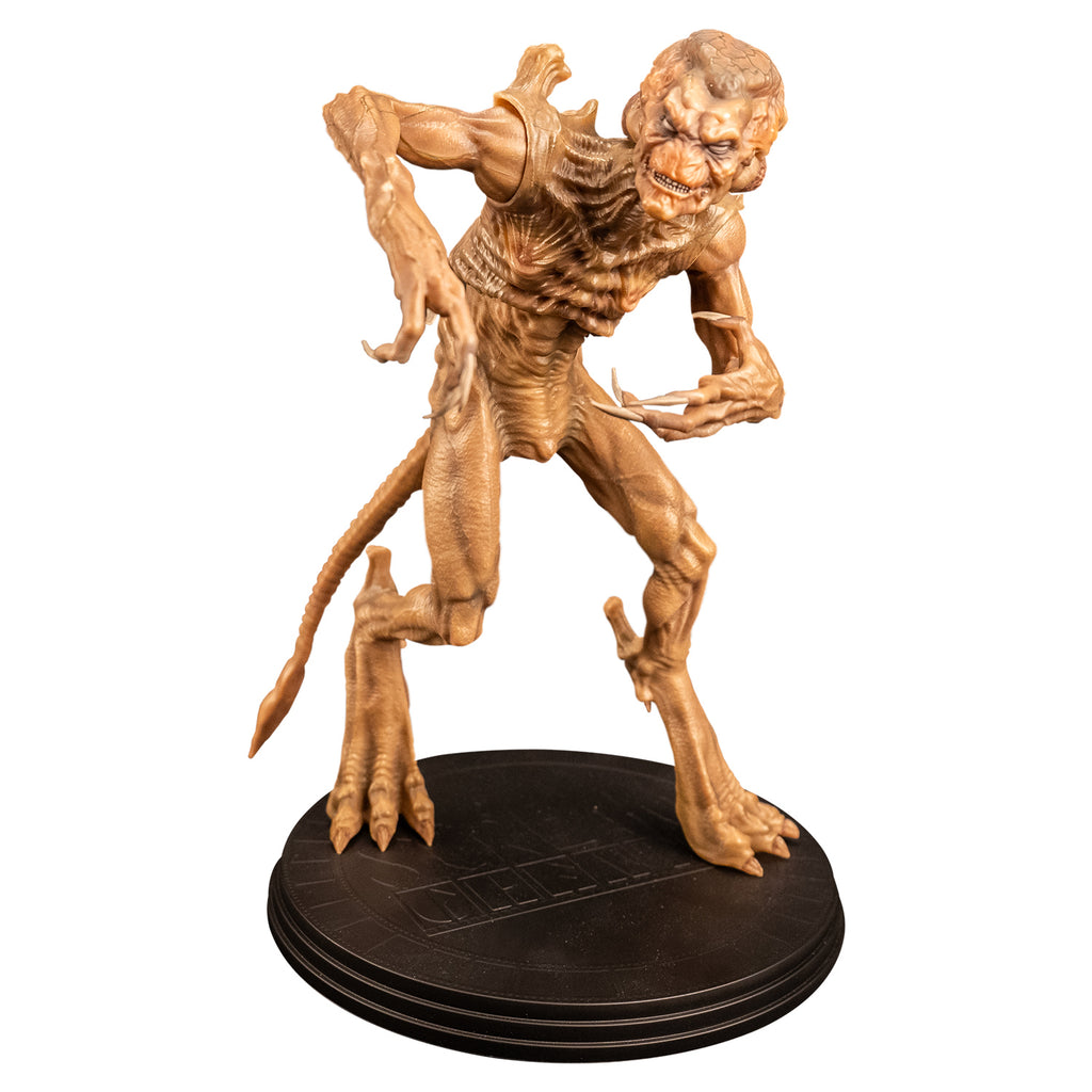 Slight right view Pumpkinhead 8" scale figure. Pale orange tan creature with enlarged upper head. White eyes, animal-like muzzle, mouth showing sharp yellow teeth. Bony with defined muscles, protrusions on shoulders, long limbs and tail. Hands have 4 long fingers and claws. Animal-like 3 toed feet with bony protrusions on heels, short claws. standing on black round platform.