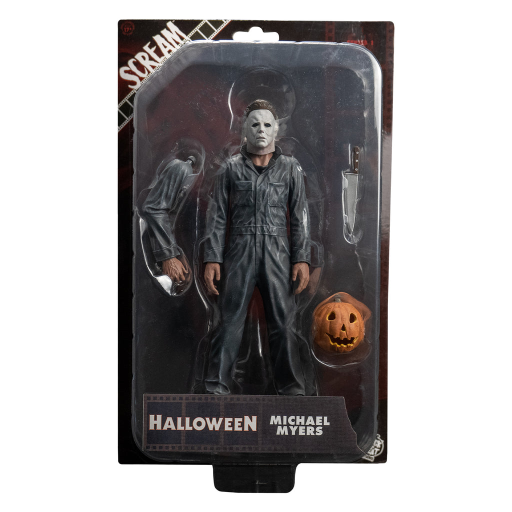 Product packaging front view.  Blister packaging on cardboard backing.  Contains the figure and right arm, kitchen knife and jack o' lantern accessories.  White text on packaging reads Scream Greats, Halloween, Michael Myers.  White Trick or Treat Studios logo bottom right.
