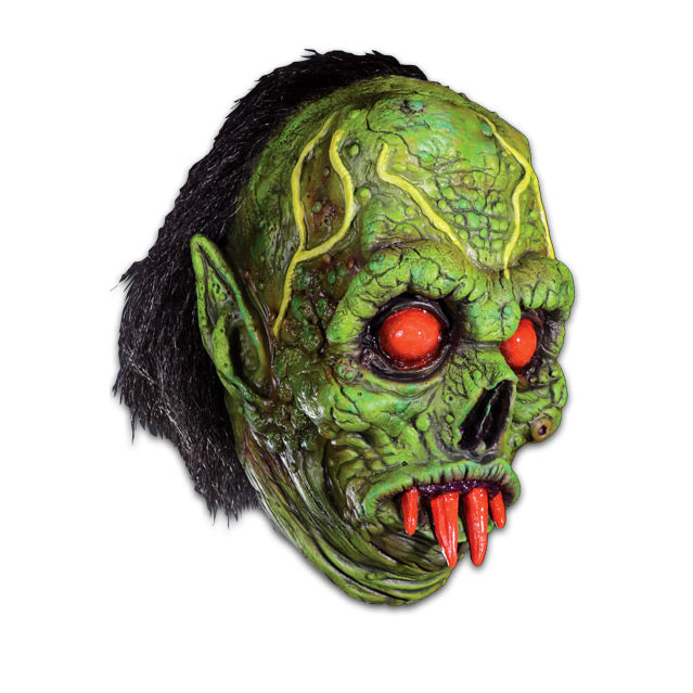 Mask, right side view. Green wrinkled and decaying flesh, bulging yellow veins on forehead, black hair, black-rimmed red-orange eyes, four red orange fangs in mouth. Pointed ears.