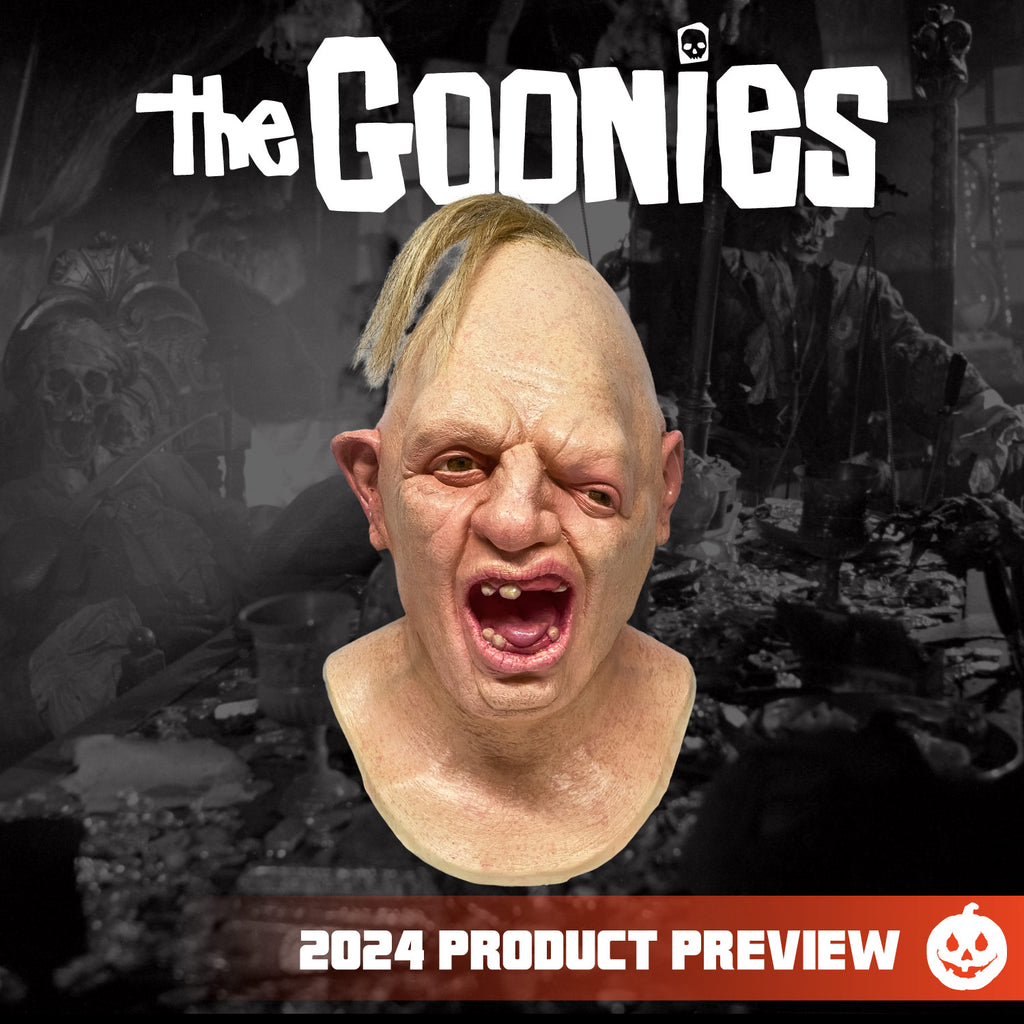 Black and white background.  White text at top reads The Goonies. Sloth character Mask, head, neck and upper chest. Egg shaped head, tuft of disheveled blond hair on top. No eyebrows, light brown eyes offset, left eye lower than the right. Large crooked nose. Deformed right ear. Mouth wide open showing pink tongue and gums and only 6 teeth. Orange horizontal banner at bottom, white text reads 2024 product review, white jack o' lantern