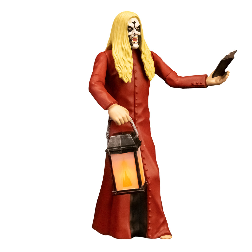 Action figure, right side view. Man, blond hair, white face with black cross on forehead, black around eyes, mouth and cheeks. Wearing floor length red, button down coat, holding book in left hand, lantern in right hand.