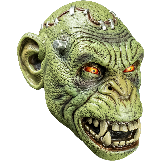 Mask, right side view. Lab chimp, Green flesh, metal staples in scalp, metal posts at temples. Yellow and red eyes, small pupils, scowling open mouth showing teeth.