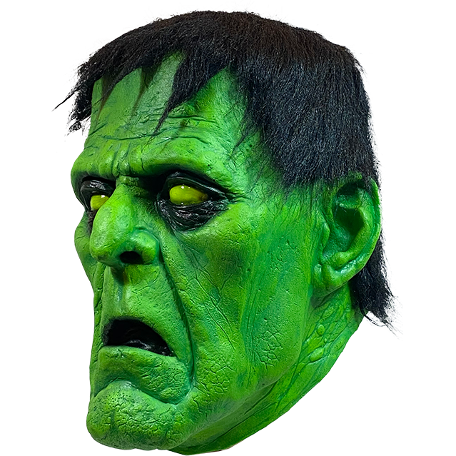 Mask, left side view. Green Frankenstein face, black-rimmed yellow eyes, black hair. mouth open.