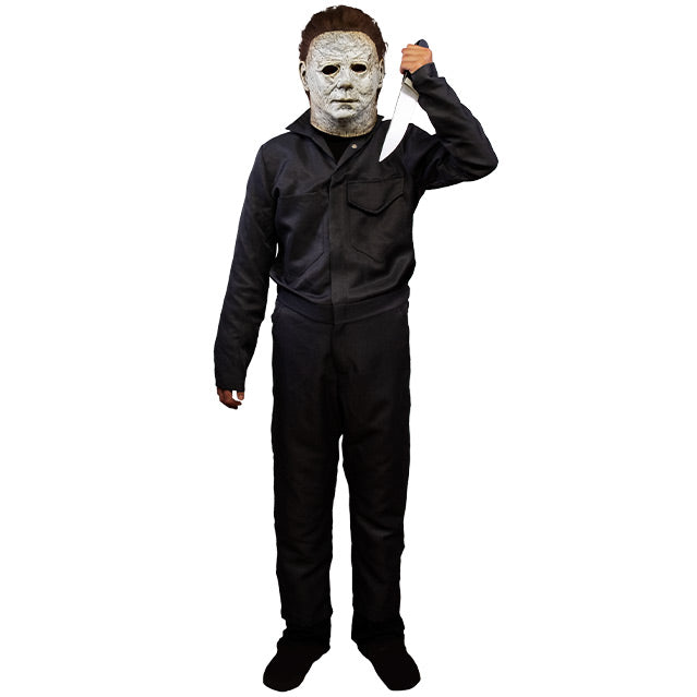 Child in Michael Myers mask and dark coveralls, holding a butcher knife in left hand.