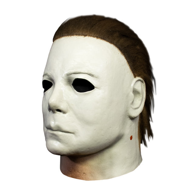 Michael Myers mask, left side view. Head and neck. Dark brown hair, white skin, flesh colored around bottom of neck.