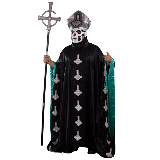 Man in Papa Emeritus robe, mask and hat. Holding tall black and silver staff. Topped with inverted cross, with semi circle that looks like a G.