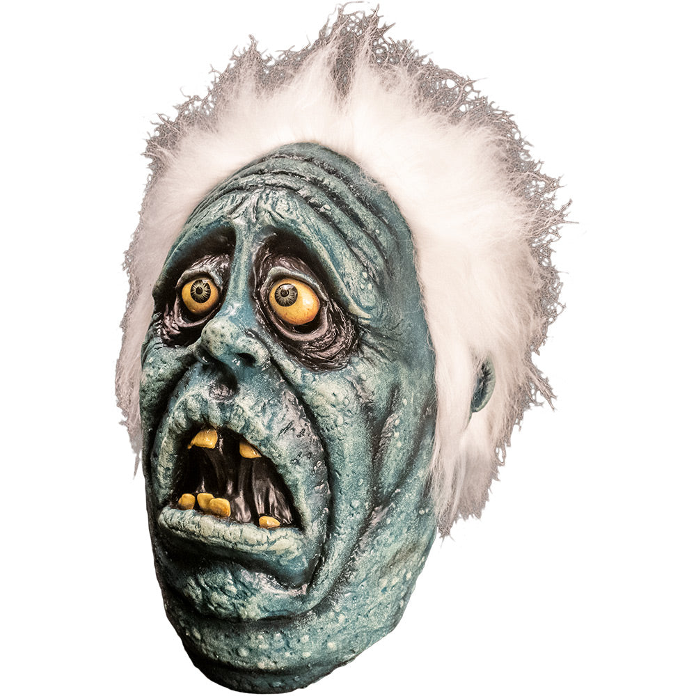 Mask left side view. Scared blue face with wrinkled sagging skin, Black circles around yellow eyes with blue irises. Open mouth with crooked yellow teeth. Bright white fluffy hair.