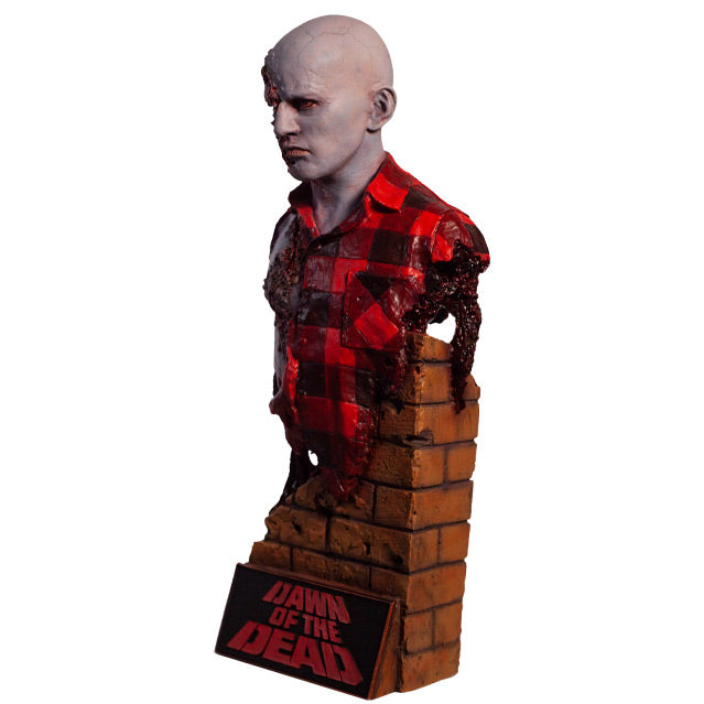 Left side view. Airport Zombie bust. Head shoulders and upper torso. Bald zombie, right side of face and chest is gory, wearing torn red and black flannel shirt, with gore hanging from left shoulder. Base of bust is a broken brick wall, plaque at bottom, red text reads Dawn of the Dead.