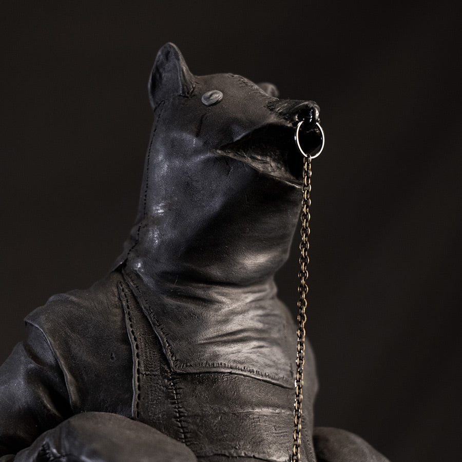 Close up of leather bear face with ring through nose attached to chain.