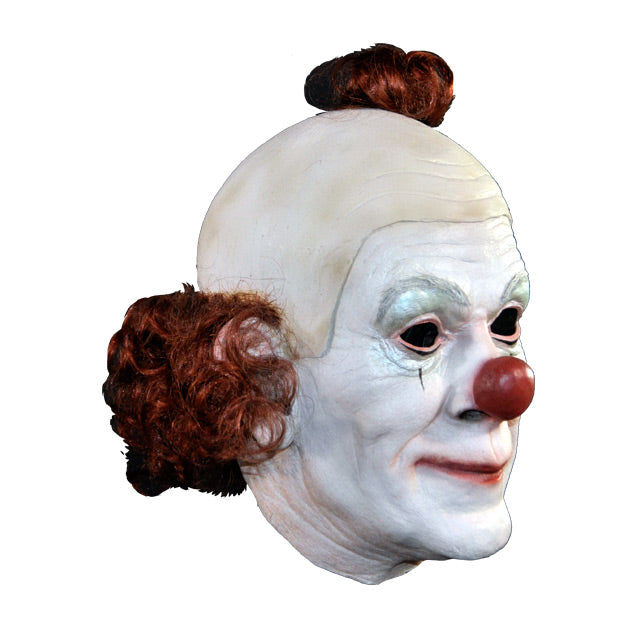 Right side view. Clown Mask. White face, red nose, one small black line below each eye. wig partially bald, red hair pompom on top, red curly hair around back ear to ear.