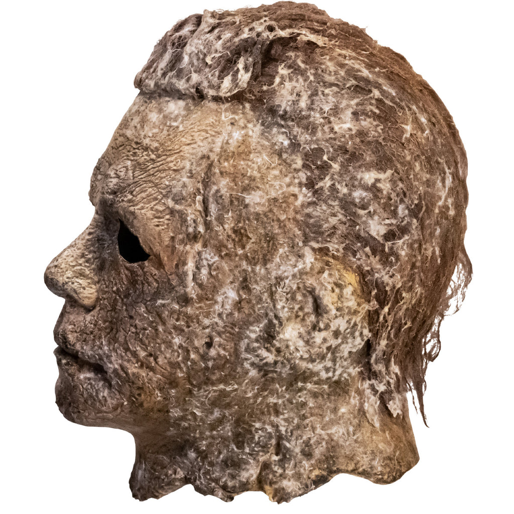 Left side view. Mask, head and neck. Brown hair, weathered, dirty moldy skin.