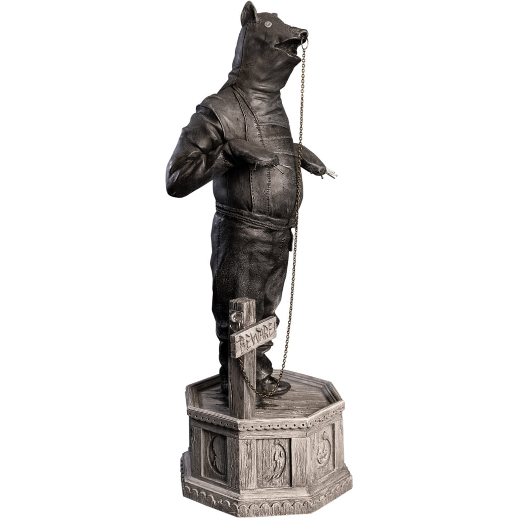 Right side view, statue. Grayscale, Person in leather bondage bear costume, with metal claws on hands, ring in nose attached to chain that is attached to a cross, that says Beware, by his feet. Standing on hexagon base made of gravestones.