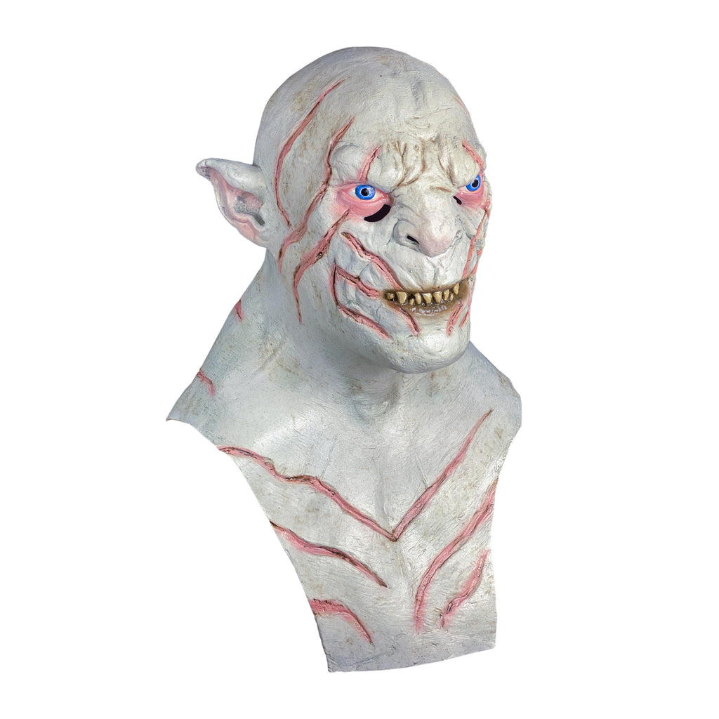 Mask, head, neck and chest, right side view. Orc, bald, white flesh, pointed ears, pink-rimmed blue eyes, sharp yellow teeth in mouth, dark pink stripes on head, face and chest.