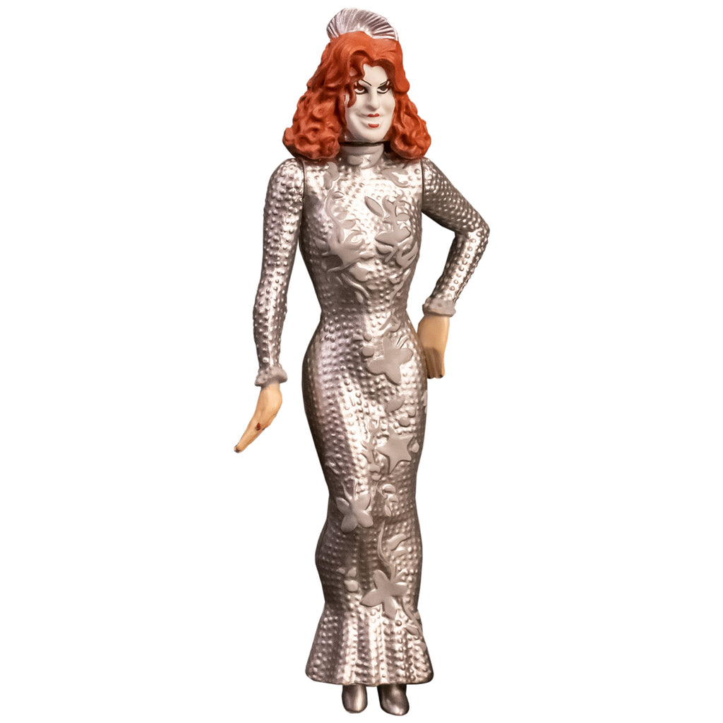 Action figure, front view. Showtime Baby Firefly, woman with red hair, pale makeup, wearing long sleeved floor length silver dress. 