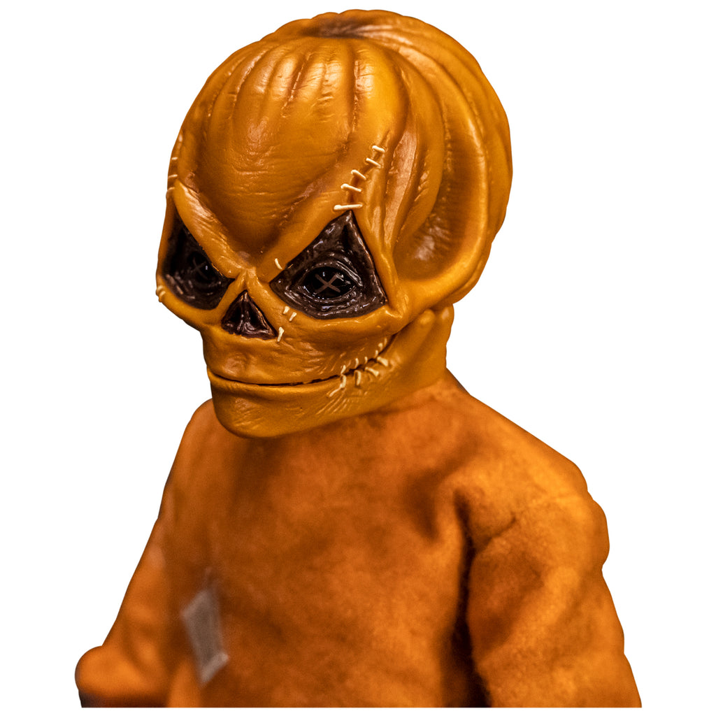 Left view. Close up of upper body and head of Trick 'r Treat Sam 1/6 scale figure with Sam Unmasked head. Head is Skull-like jack o' lantern face, stitches above eyes and sides of mouth, mouth closed in grin. Wearing orange footy pajamas