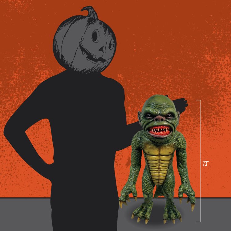 Man in black with jack o' lantern head standing next to puppet prop to show size.  23 inches