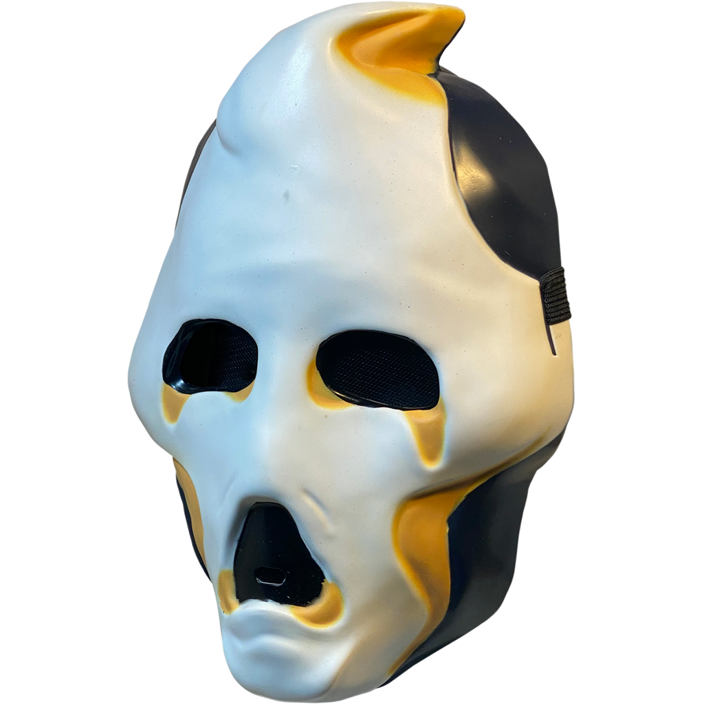 Plastic mask, left side view. White ghost face, black on sides of head and jaw. Black eyes and open moaning mouth. Yellow at tip of pointed head, around bottom of eyes and mouth and below cheeks.