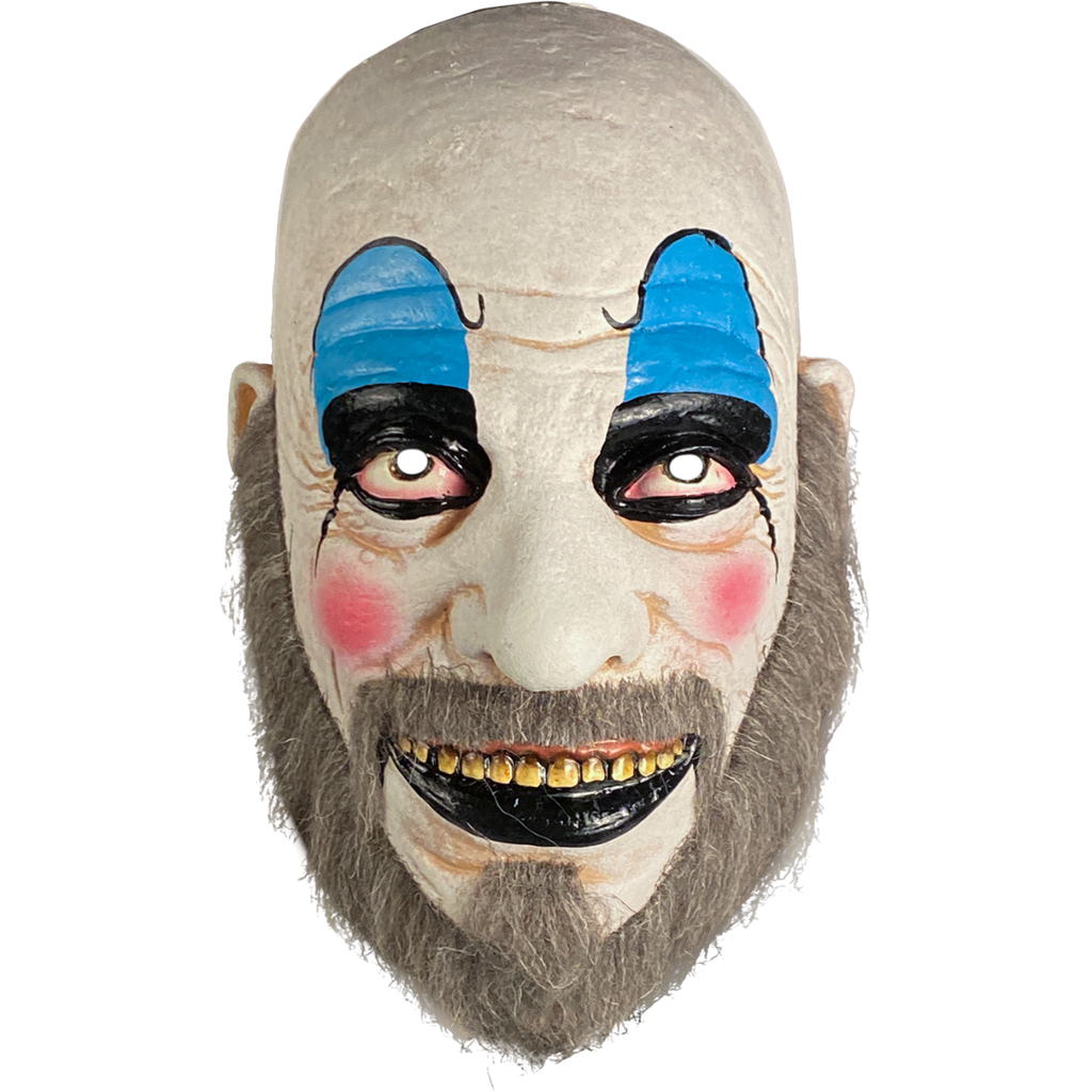 Face mask, front. Bald man in white clown makeup, high black eyebrows, blue eyeshadow, black circles around eyes, pink spots on cheeks, large menacing grin, black bottom lip, full gray beard.