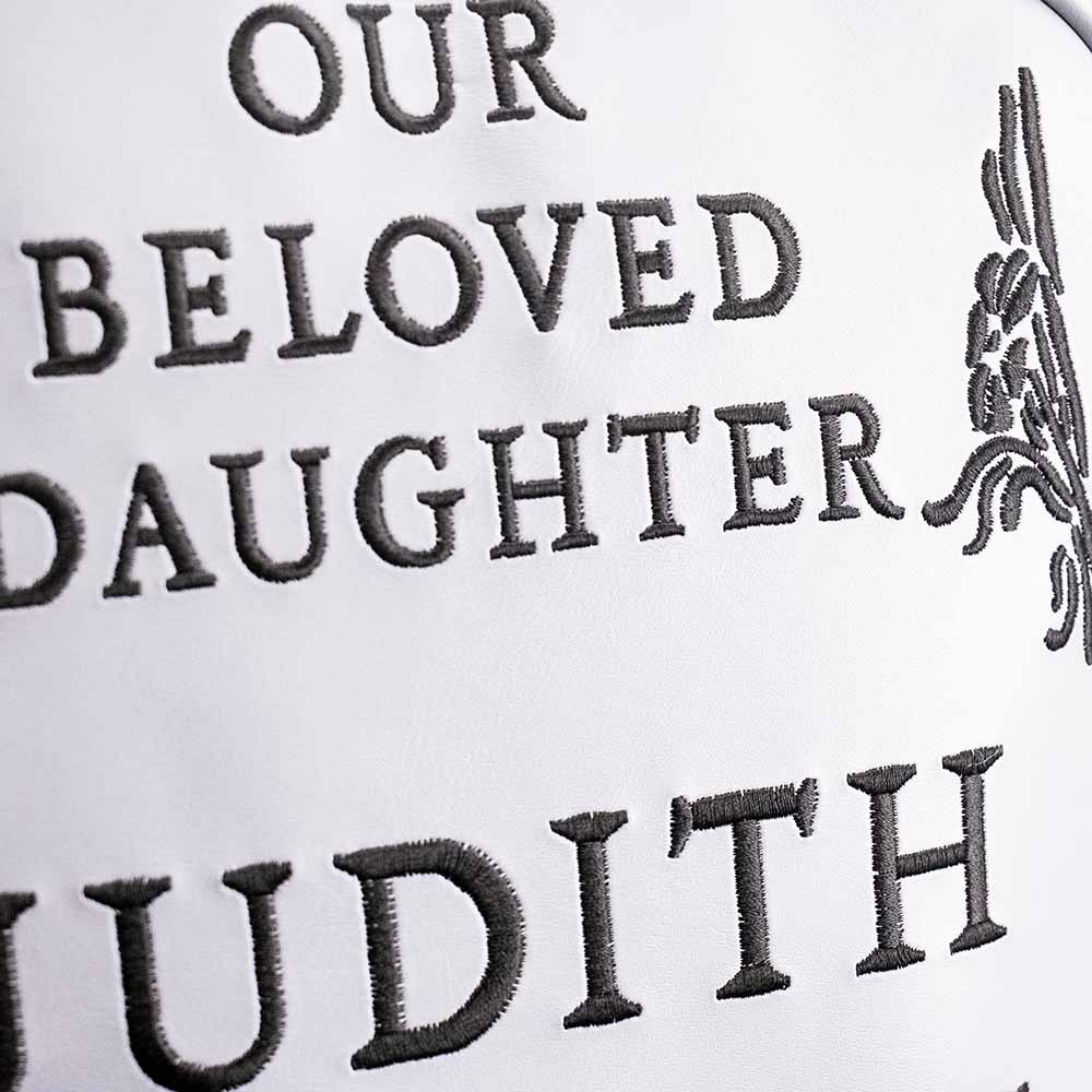 Close up of text on gray bag reads Our Beloved daughter Judith.