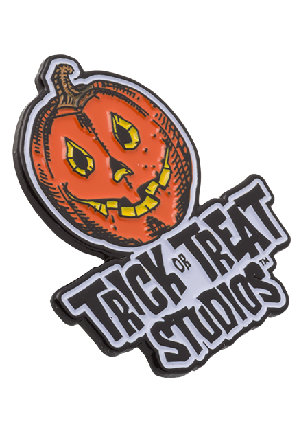 Enamel Pin. Side angle view. Orange yellow and black Jack o' lantern with smiling mouth, above black text that reads Trick or Treat Studios. on a white background.