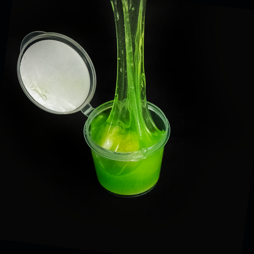 Clear container, open, green slime stretched being removed from container