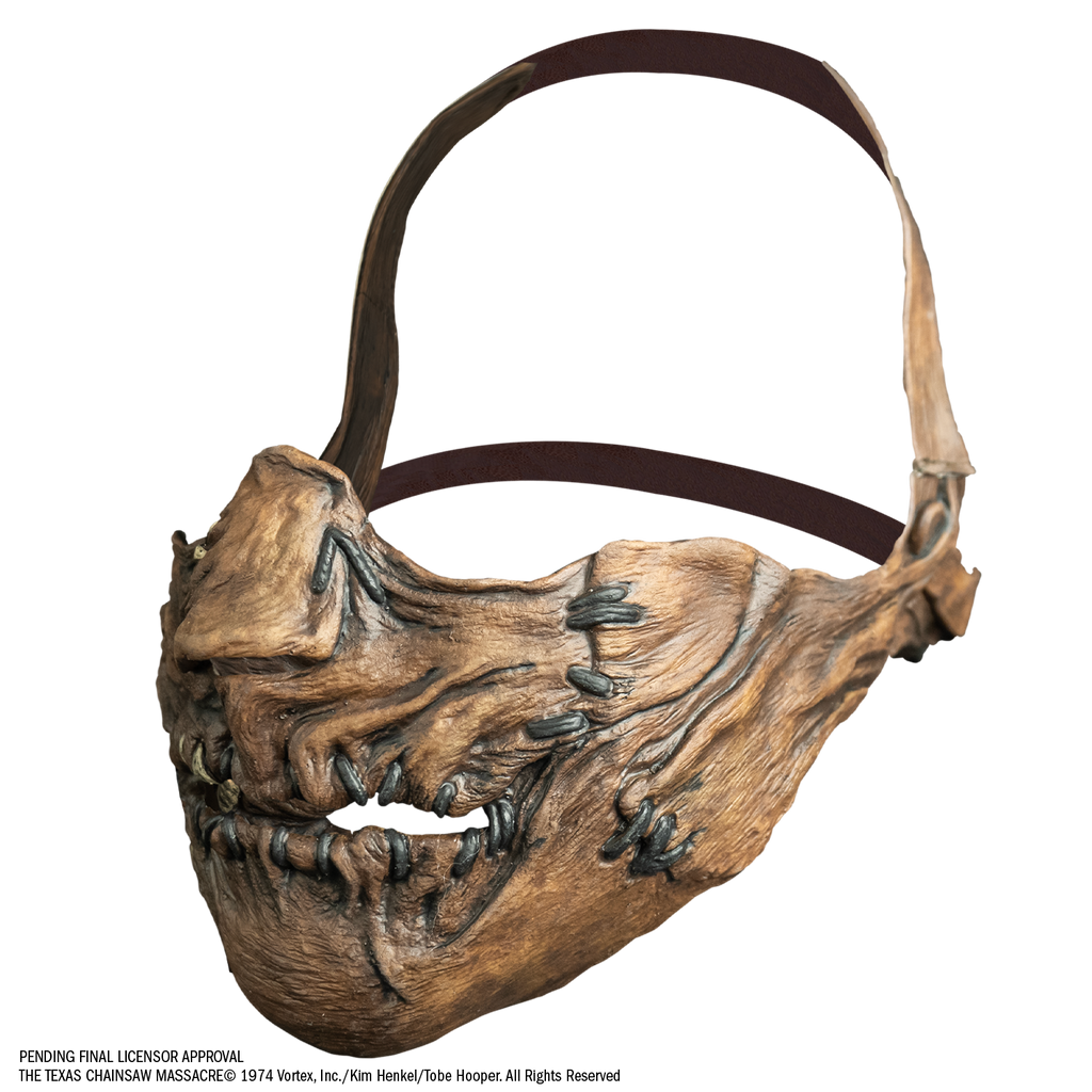 mask, left view. Lower face only, with strap that goes from cheeks around the back of the head, and strap that goes around the back of the lower part of the head. . lower face wrinkled flesh sewn together at nose, sides of mouth and lips