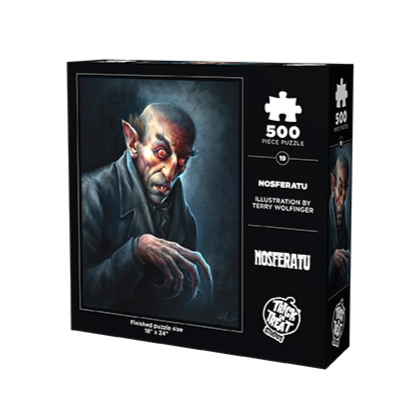 Packaging, back. Black box, white text reads 500 piece puzzle, illustration by Terry Wolfinger, Nosferatu, white Trick or Treat Studios logo. Illustration of Nosferatu vampire, head and shoulders, black and white background, balding with brown hair above very pointed ears, bushy black eyebrows, black-rimmed red eyes, mouth slightly open showing two sharp front teeth. Wearing black shirt under black overcoat, right hand curled in claw position at chest. white text below reads finished puzzle size 18" x 24"