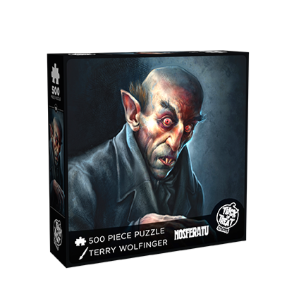 Product packaging. Cover. Black box, white text reads 500 piece puzzle, Terry Wolfinger, Nosferatu, white Trick or Treat Studios logo. Illustration of Nosferatu vampire, head and shoulders, black and white background, balding with brown hair above very pointed ears, bushy black eyebrows above black-rimmed red eyes, mouth slightly open showing two sharp front teeth. Wearing black shirt under black overcoat, right hand curled in claw position at chest