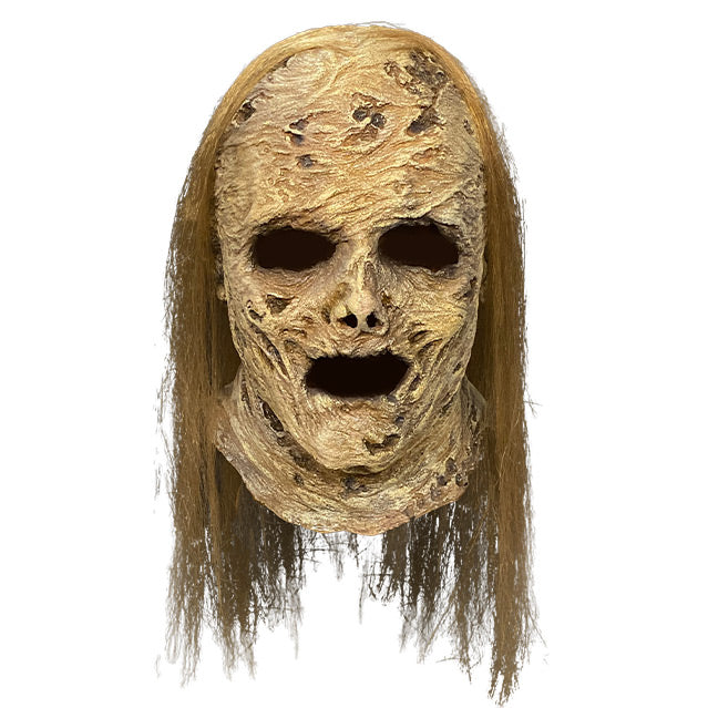Mask, head and neck. Decayed and wrinkled tan flesh.  Empty eye and mouth holes. Long stringy blond hair.  