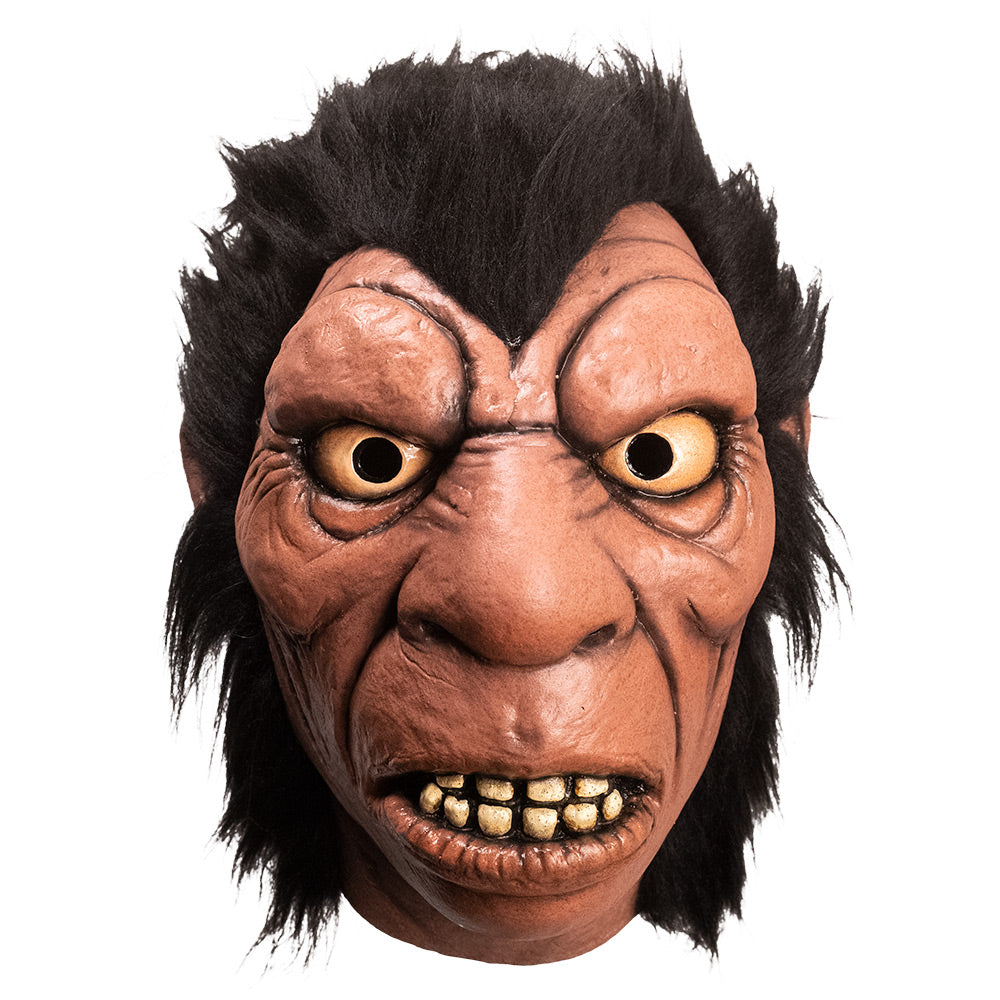 Mask, front view. Cartoon caveman face. Bushy brown hair, large brow, nose and mouth with large dirty teeth.