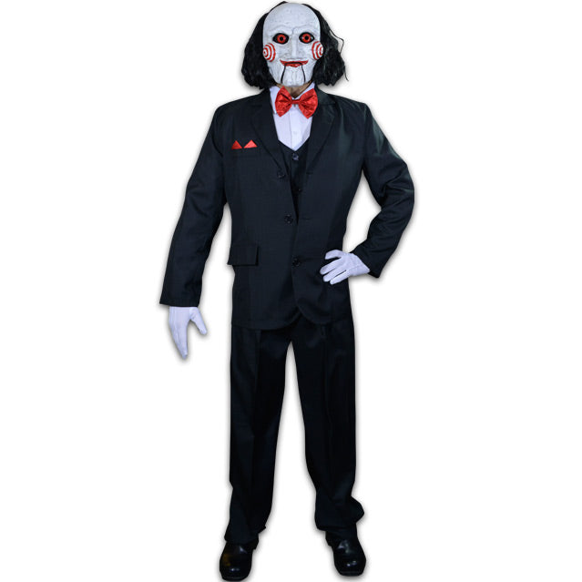 Person wearing Costume, Saw Billy Puppet mask, balding with black hair, white face, black-rimmed red eyes, red spirals on cheeks, red lips on hinged ventriloquist dummy mouth. Wearing red bowtie, white collared shirt, black vest and suit coat, white gloves, black pants and black shoes.