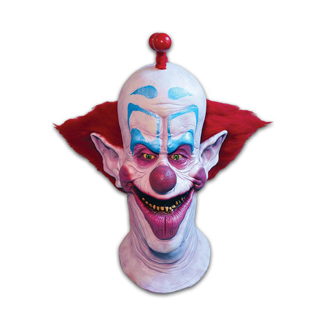 Mask, head and neck. Exaggerated scary clown face.  White skin, red bauble mohawk, red spiky hair on sides of head.  Blue eyebrows and eyeshadow, pink around eyes on large nose and cheeks.  Large pointed ears.  Open mouth with oversized pink bottom lip, yellow teeth.